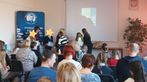 3 kobiety wręczają nagrody dzieciom. Twarze dzieci zasłonięte gwiazdkami.