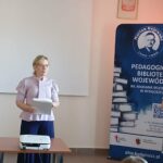 Kobieta w jasnej koszuli trzyma plik kartek.