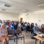 Sala audytoryjna pełna siedzących osób.