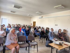 Sala audytoryjna pełna siedzących osób.
