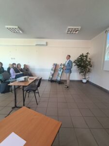 Mężczyzna w niebieskiej marynarce mówi do siedzącej publiczności.