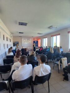 Sala audytoryjna fotografowana od tyłu - widać plecy siedzących.