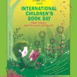 Chłopiec czyta książek leżąc oparty na drzewie.