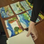 Dłoń chwyta kartkę papieru, obok 6 ilustracji akwarelowych.