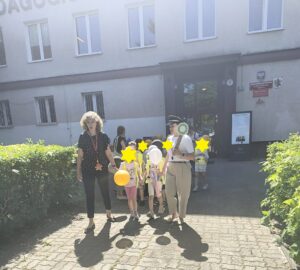 Pochód dzieci z balonami prowadzą dwie kobiety.
