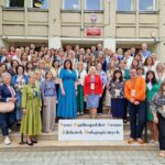 Grupowe zdjęcie na schodach. Duża grupa, przeważają kobiety.