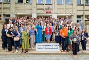 Grupowe zdjęcie na schodach. Duża grupa, przeważają kobiety.