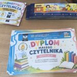 Kolorowe dyplomy, zakładki i bilety na blacie stołu.