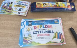 Kolorowe dyplomy, zakładki i bilety na blacie stołu.