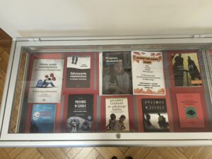 Publikacje prezentowane w gablocie bibliotecznej na czerwonym tle.
