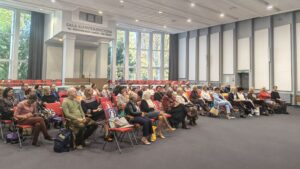 Sala audytoryjna pełna siedzących osób.